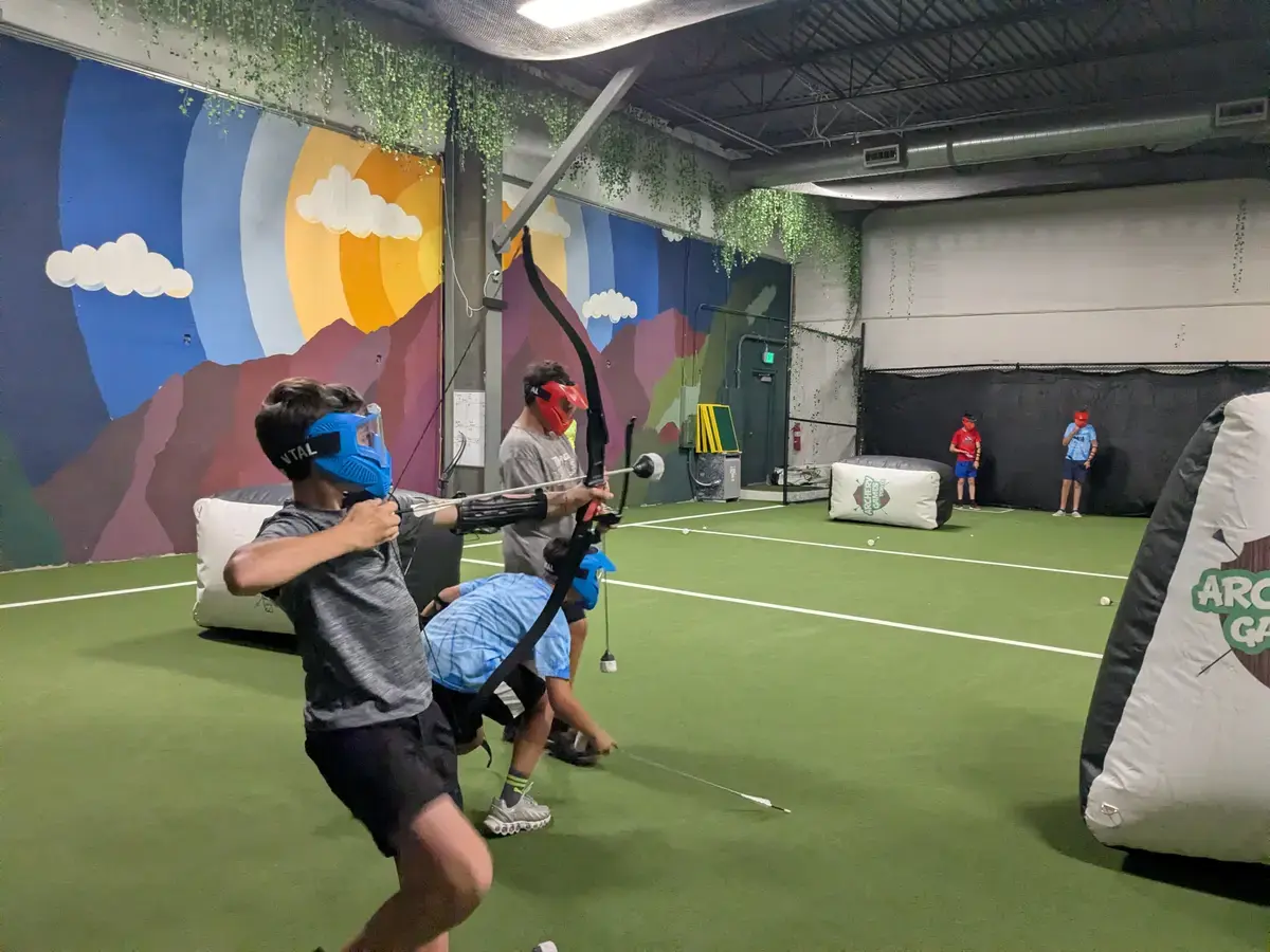 Camper drawing a bow at the indoor archery range
