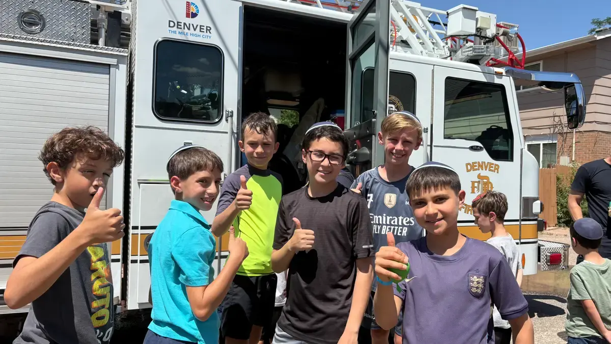 Campers giving thumbs up next to the camp van