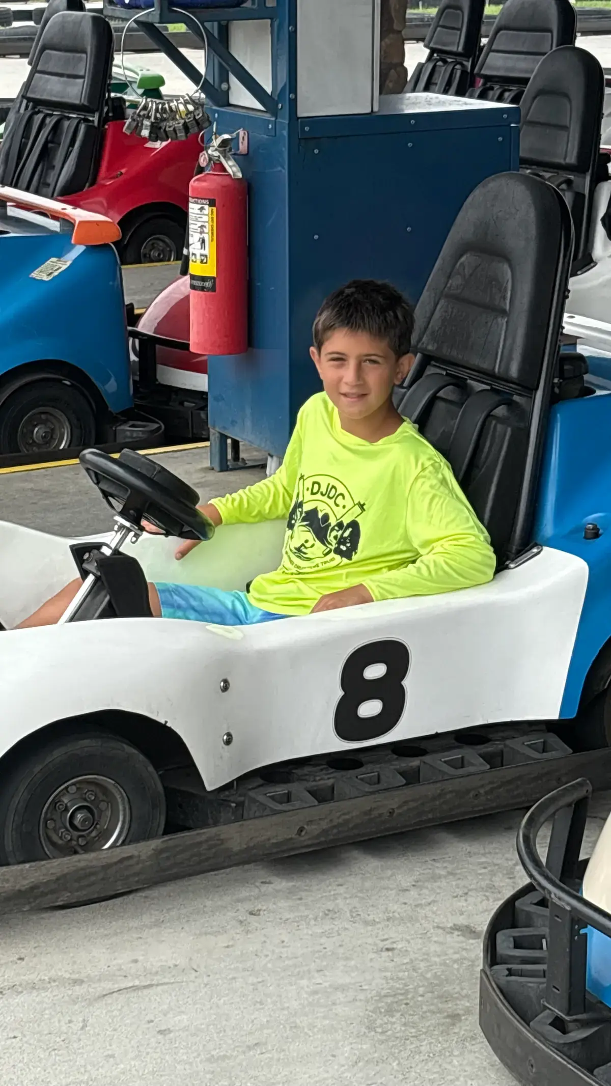 Camper behind the wheel of a number 8 go-kart
