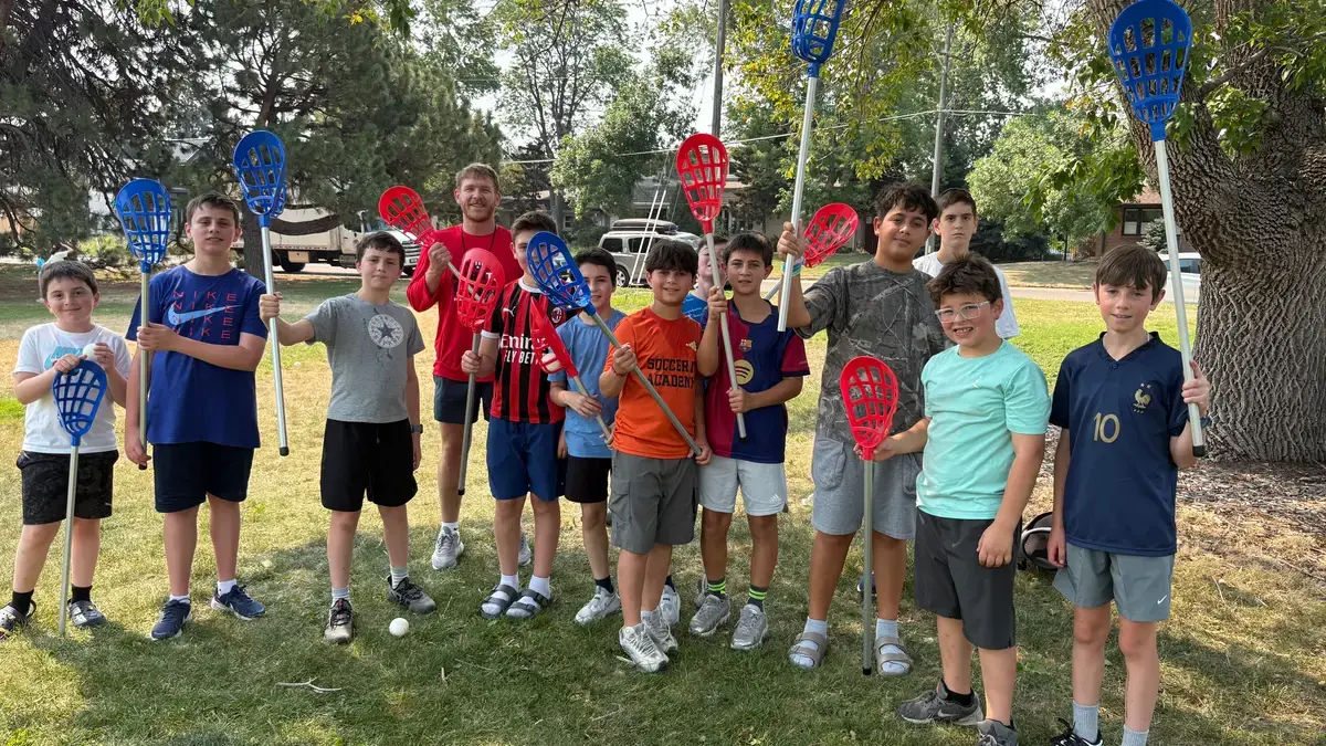 Campers holding up red rackets after a clinic